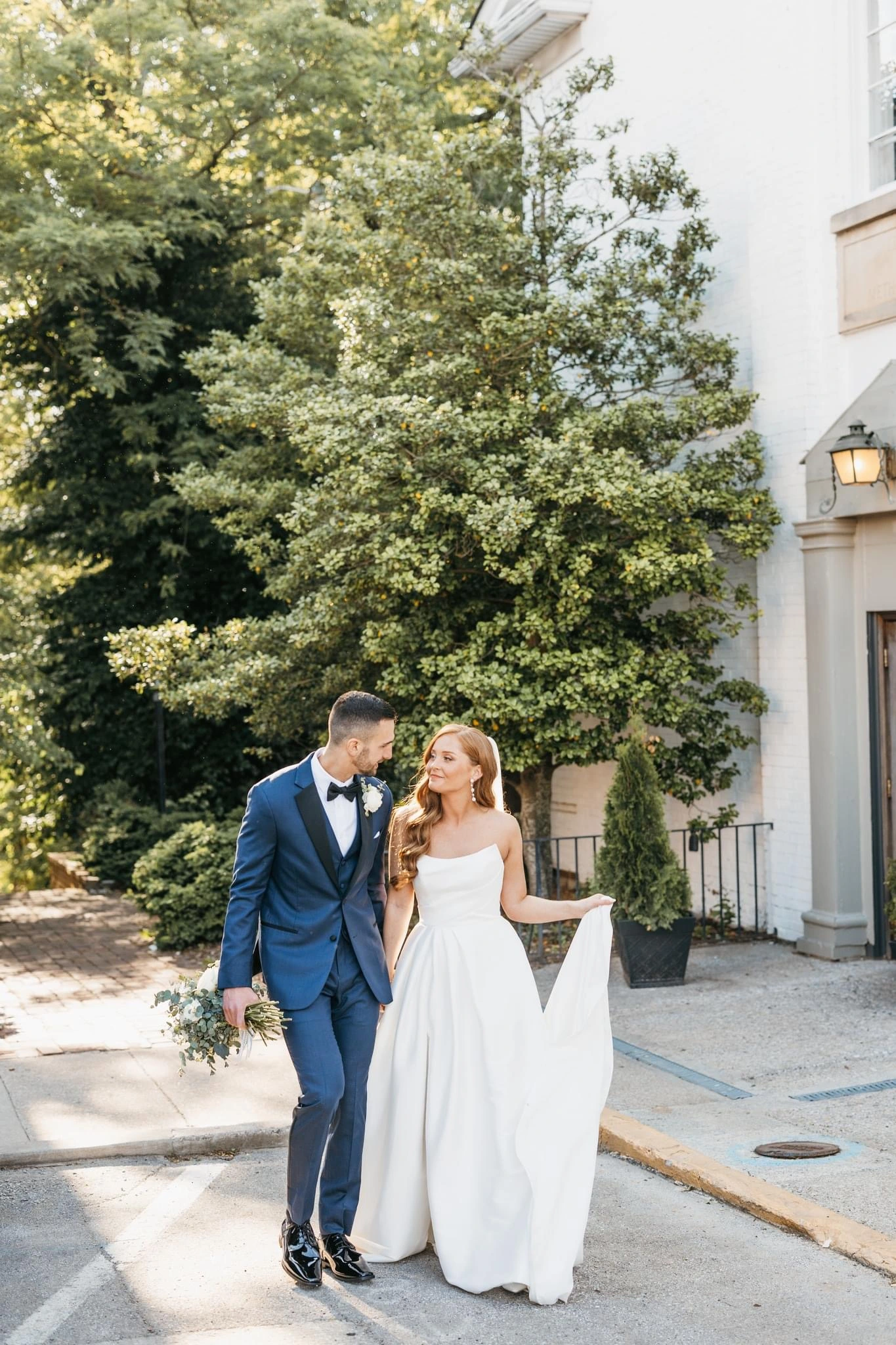 Bride wearing Aspen A-line wedding dress by Sottero and Midgley standing outside with her husband.