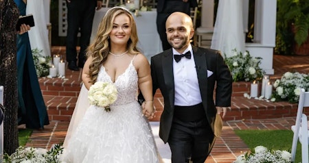 Lona wearing Marvine A-line wedding dress by Sottero and Midgley and walking with her husband. 