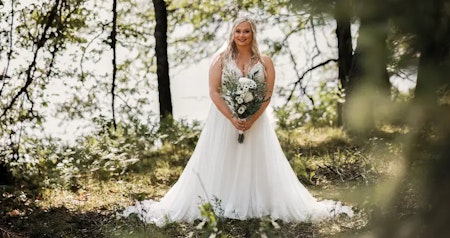 Bride wearing Lorraine boho wedding dress by Rebecca Ingram in the forest.