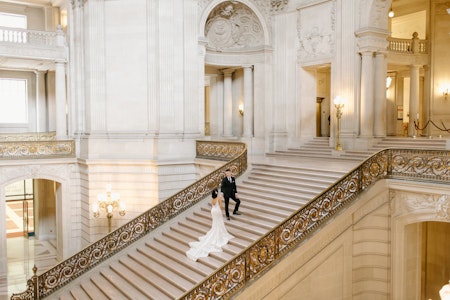 Bride wearing Bailey casual wedding dress by Sottero and Midgley walking up the steps at her city hall elopement.