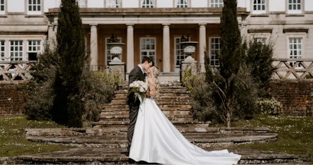 Bride wearing Raven by Maggie Sottero kissing her husband.