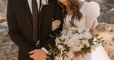 Bride wearing Kashlynn modest wedding dress by Maggie Sottero embracing her husband.
