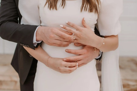 Bride wearing Kashlynn modest wedding dress by Maggie Sottero exchanging rings with her husband.