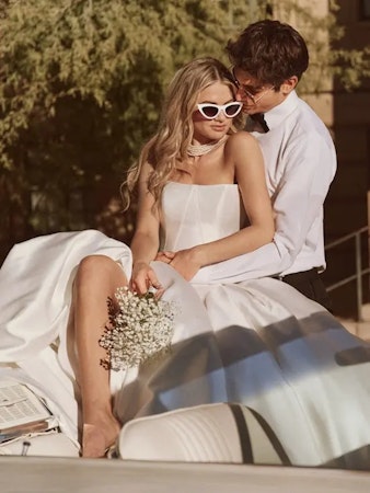 Bride wearing princess wedding dress Fortune by Maggie Sottero in the car with her husband.