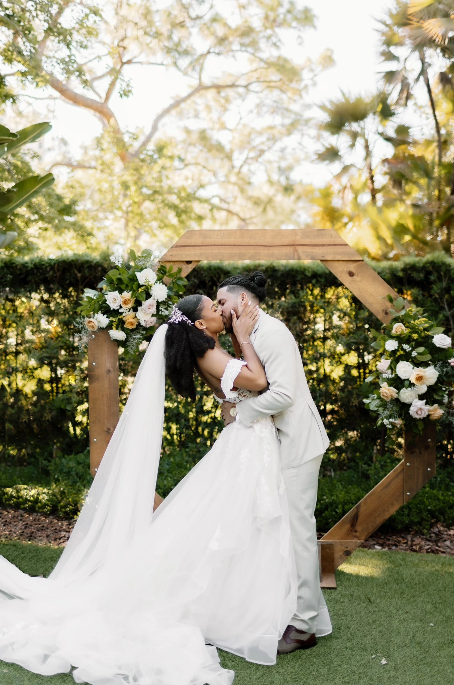 Bride wearing Lettie A-line wedding dress by Rebecca Ingram and kissing her husband.