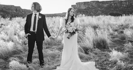 Bride wearing Kashlynn vintage wedding dress by Maggie Sottero holding hands with her husband.