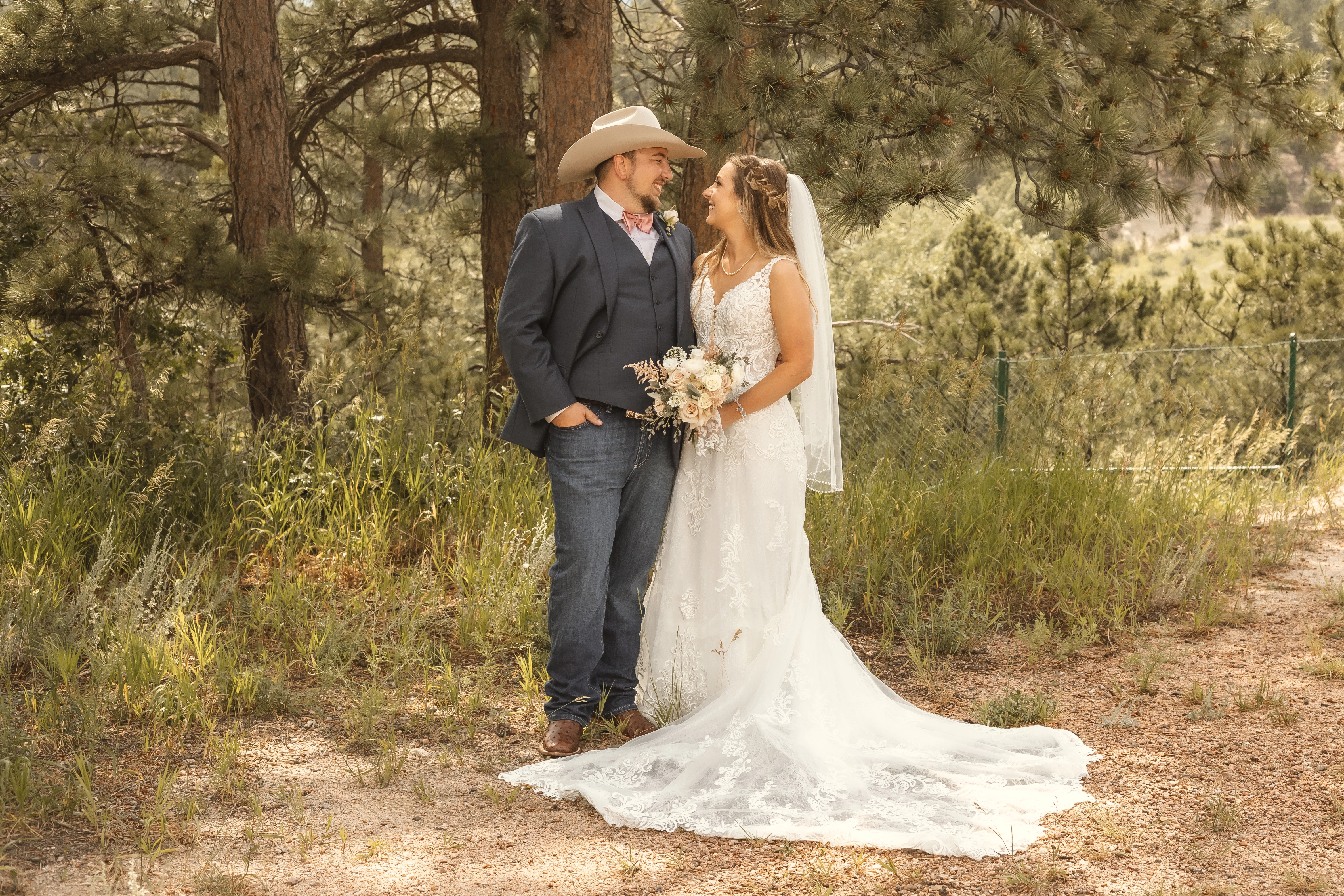 Bride wearing Johanna Western wedding dress by Maggie Sottero and smiling at her husband.