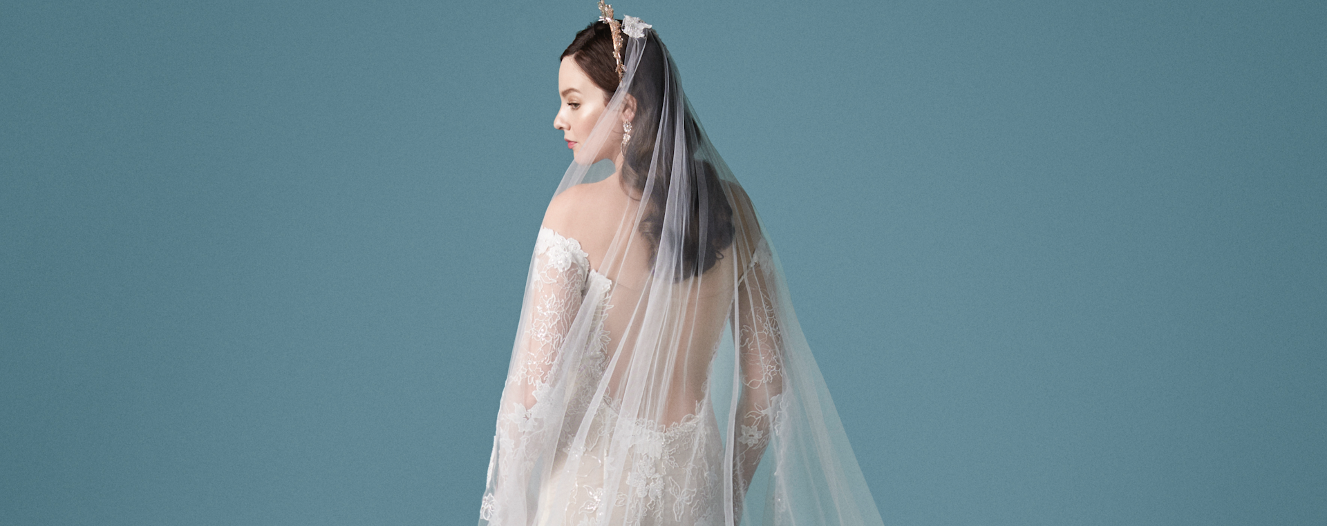 Model Wearing Backless Wedding Dress Called Emiliano by Maggie Sottero With Floor Length Wedding Veil
